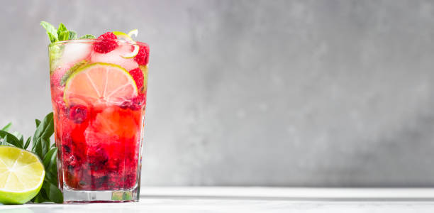 istock Pink cocktail or lemonade with raspberries, mint, lime and ice on a grey concrete table. Summer refreshment drink. Copy space. 1230013974