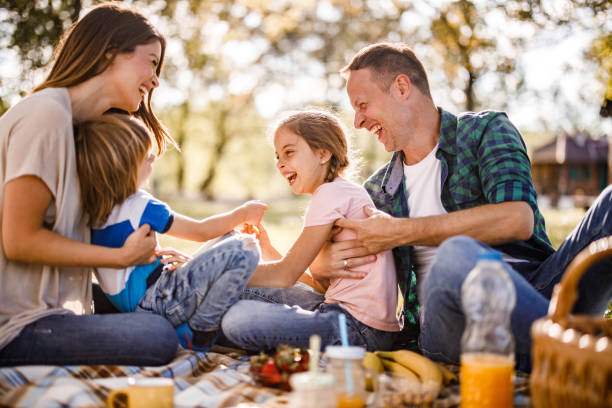 istock Cheerful parents and their small kids having fun during picnic in springtime. 1230057117