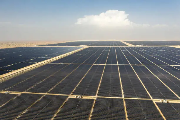 Aerial view of a landscape with photovoltaic solar panel farm producing sustainable renewable energy in a desert power plant.