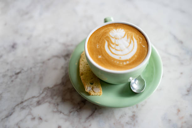 istock Frothy flat white coffee with coffee froth art on top of marble table 1230094852