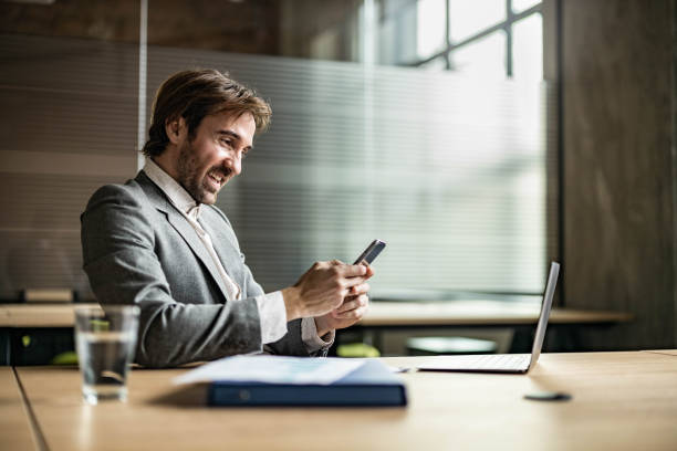 istock Young happy businessman using cell phone in the office. 1230095188