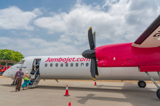 Ukunda Airstrip, Tanzania - February, 25 2020: Bombardier Aircraft at Diani Beach, Ukunda Airport with cloudy blue Sky and People going inside the Plane