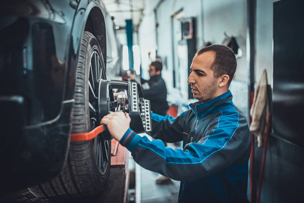 zwei junge auto-mehanic setzt die radausrichtung ausrüstung auf einem auto-rad - auto repair shop tire car mechanic stock-fotos und bilder