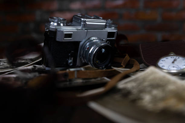 istock Vintage film camera and old photographs on a rustic surface 1230119577