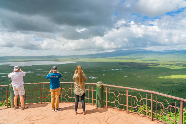 tourist blickt in den ngorongoro krater nationalpark mit dem magadisee - wildlife tracking tag stock-fotos und bilder