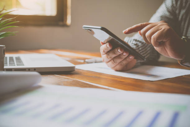 istock hand holding black mobile phone with blank white  in desk work for home. 1230144963