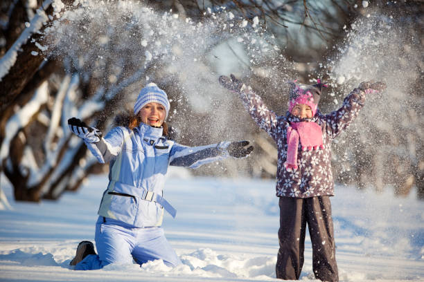 istock Mother and Daughter Throwing Snow in Winter Park 123014861