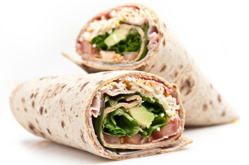 Avocado,ham, cheese,lettuce and tomato wrap sandwiches close up