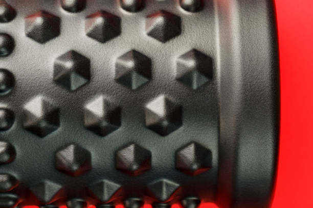 istock Black lumpy foam massage roller on red background. For the mechanical and reflex effects on tissues and organs. 1230227472