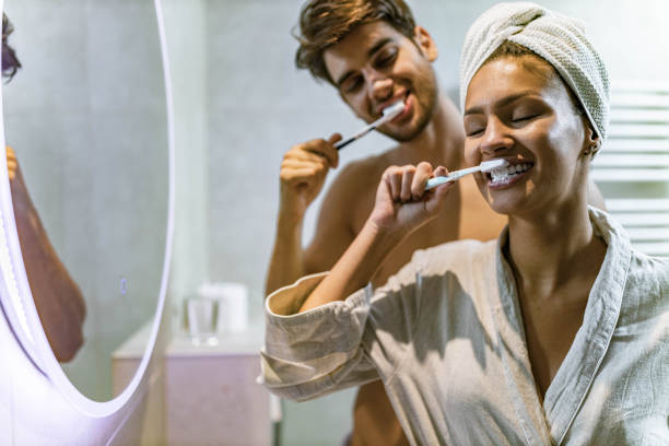 istock Young happy couple brushing their teeth in bathroom. 1230261832