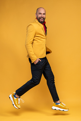 Portrait of a man wearing yellow jacket on yellow background. Styled, well dressed man.