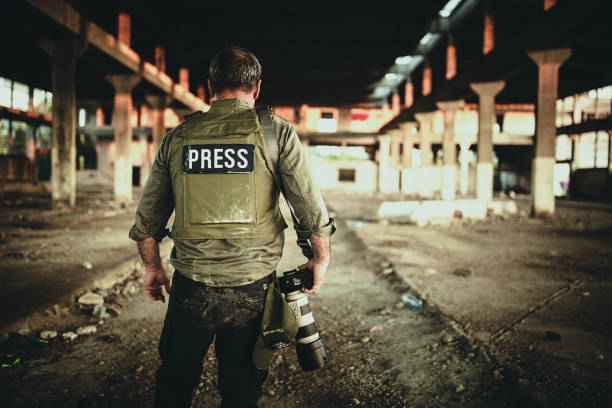 istock Man war photographer with camera in war zone 1230336807