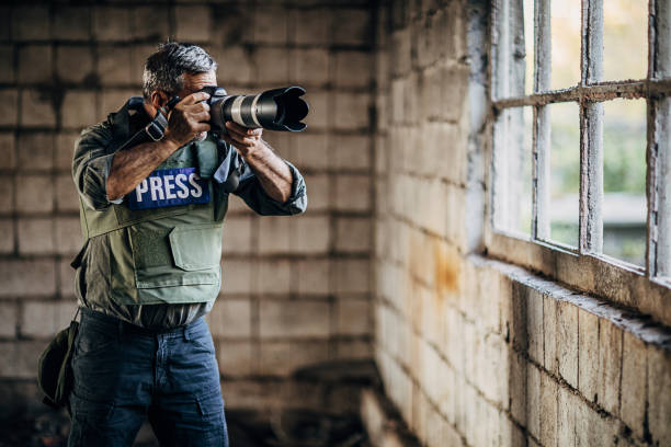 istock Mature guy war journalist taking pictures with camera 1230347016