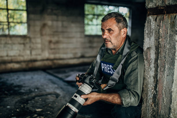 istock Mature man war reporter with camera in war zone 1230386438
