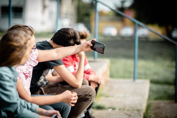 istock Teenagers using phone on the street 1230479034