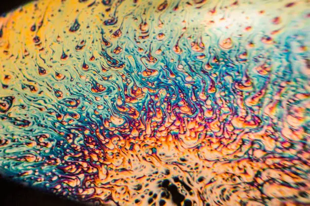 This is a picture of soap bubbles taken in a black coffee mug. The microscopic look of the bubbles is achieved by using a lens from a rear projection TV as a macro filter lens. Suitable as a background
