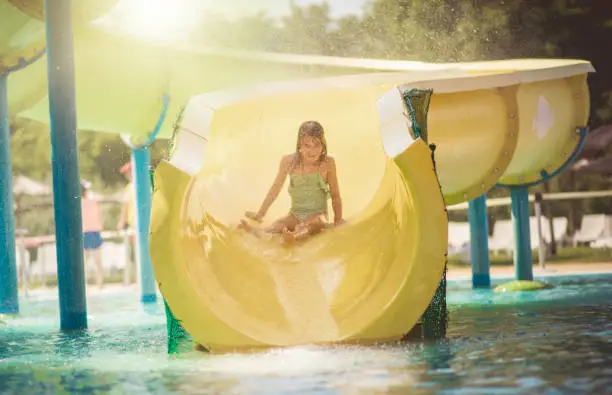 Every moment is fun. Child on pool toboggan.