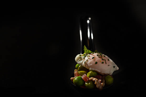 istock Spoonful of poached egg with peas, ham and red pepper 1230521183