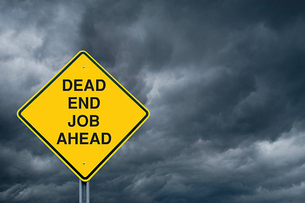 A Caution Sign in Front of Storm Clouds Warning of a Dead End Job  Ahead