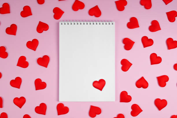 istock Notebook with red hearts on a pink background with hearts. Mock up. 1230534235