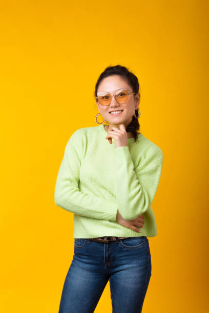 istock Smiling at the camera girl is standing over yellow background. 1230550147
