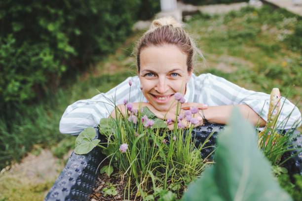 istock woman posing next to raised garden bed 1230572163