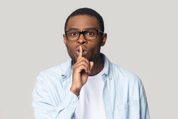 istock African man put finger on lips makes hush gesture 1230617381