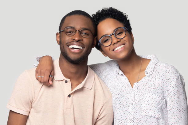 African couple embracing smiling looking at camera posing on grey Head shot portrait African attractive married couple in glasses embracing smiling looking at camera posing isolated on grey background, love and relations, clients of photo shooting in studio concept black man white woman couple stock pictures, royalty-free photos & images
