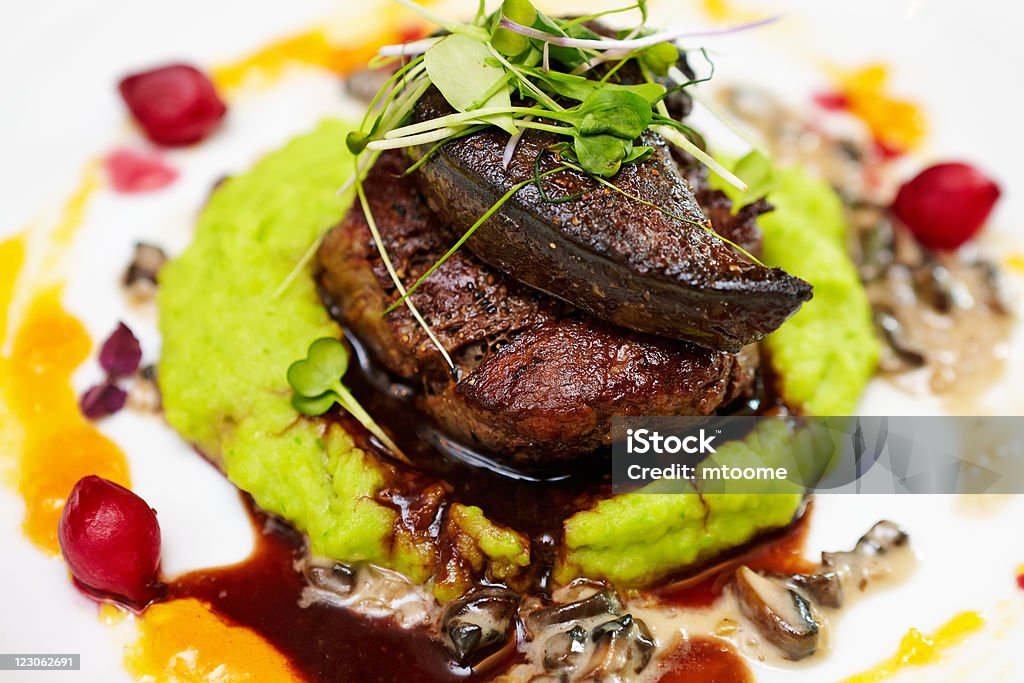 Fillet of beef Fillet of beef with elk liver served with mashed potatoes and peas, creamy mushroom stew and red wine and blueberry sauce Elk Stock Photo