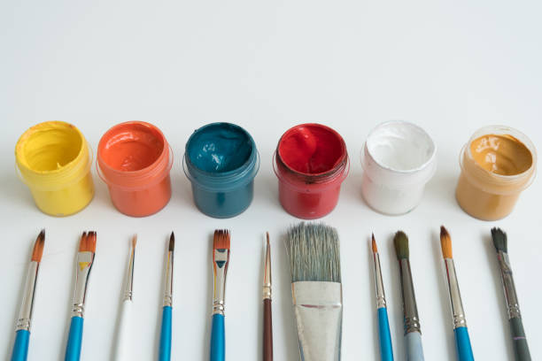 istock Open jars with gouache and paint brushes of different sizes. The view from the top. Background, texture. The concept of space for creativity and choice. 1230651221