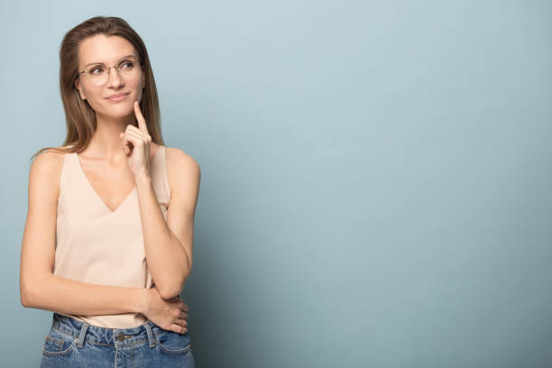 istock Thoughtful woman touch chin, looking to right at copy space 1230695294