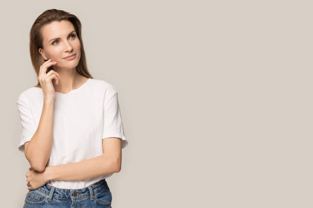istock Pensive attractive woman looking aside at blank copy space 1230695397