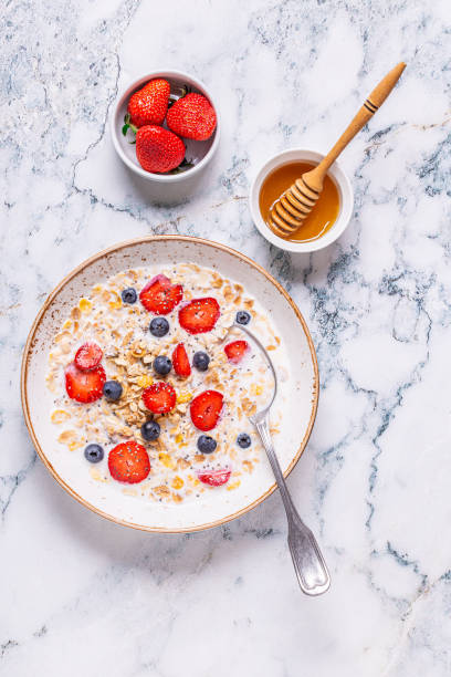 здоровый завтрак, чаша с овсяной гранолой, молоком и ягодами - milk breakfast berry fruit granola стоковые фото и изображения