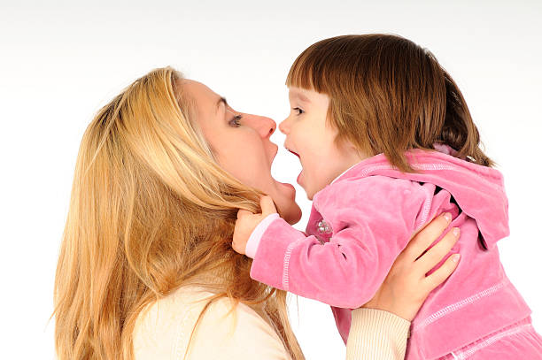 Mother kissing smiling little girl.