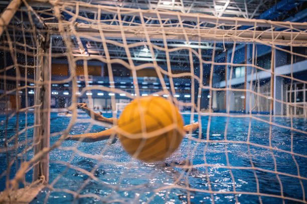 istock Young man scoring a goal in water polo match 1230724168