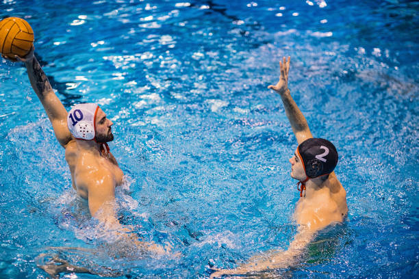 istock Two men playing water polo game in the indoor pool 1230740060