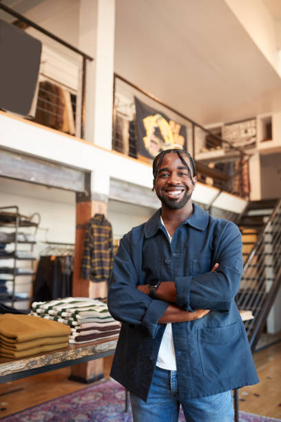 portret uśmiechniętego mężczyzny właściciela sklepu mody stojącego przed wyświetlaczem odzieżowym - clothing store sales clerk usa clothing zdjęcia i obrazy z banku zdjęć