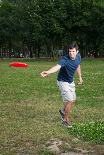 young man playing frisbee outdoors