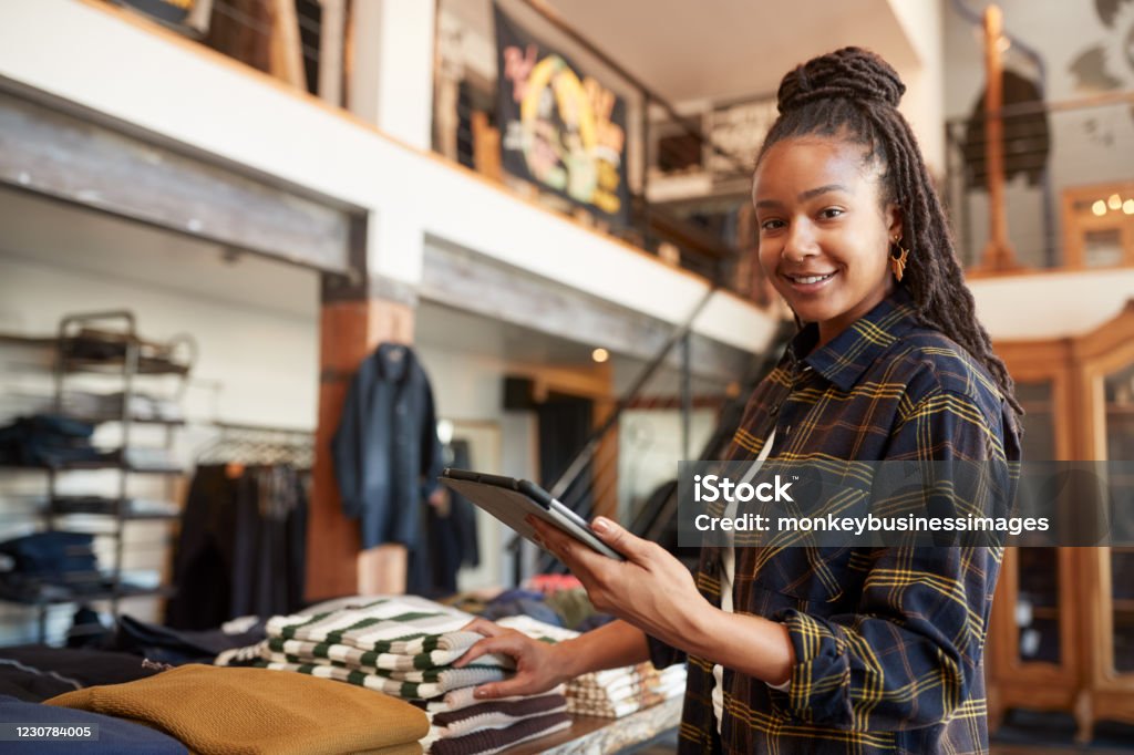 Portrait Of Female Owner Of Fashion Store Using Digital Tablet To Check Stock In Clothing Store Entrepreneur Stock Photo