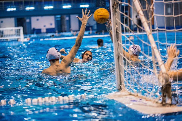 istock Group of young men playing a water polo game 1230789192