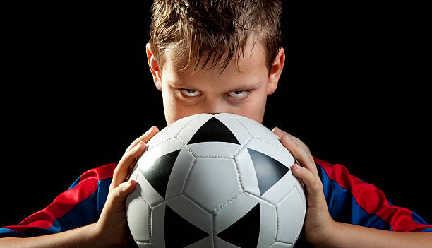 boy stares with ball frontal stock photo