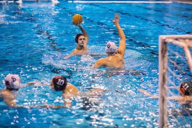 istock Group of men playing a water polo game indoors 1230802506