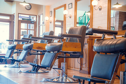 Empty chairs in stylish barbershop. Hair salon interior. Professional hairstylist barbershop