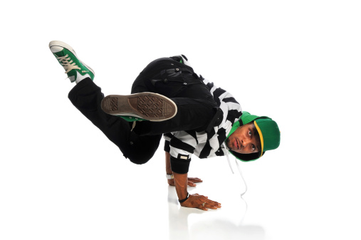 Portrait of African American hip hop dancer balancing on hands isolated over white background