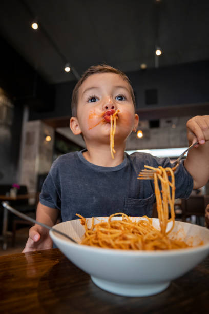 これはパスタを食べる方法です - child eating pasta spaghetti ストックフォトと画像