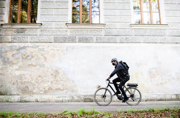 istock Delivery man courier with face mask and bicycle using smartphone in town. 1230838596