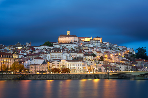 Coimbra, Portugal - April 10, 2019 : Coimbra city view at night with Mondego river and beautiful historic buildings, in Portugal