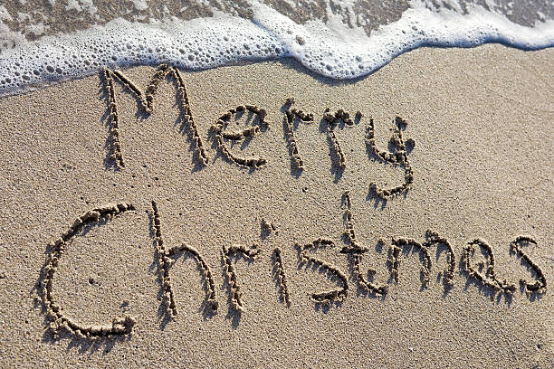 Merry Christmas written on the sand stock photo