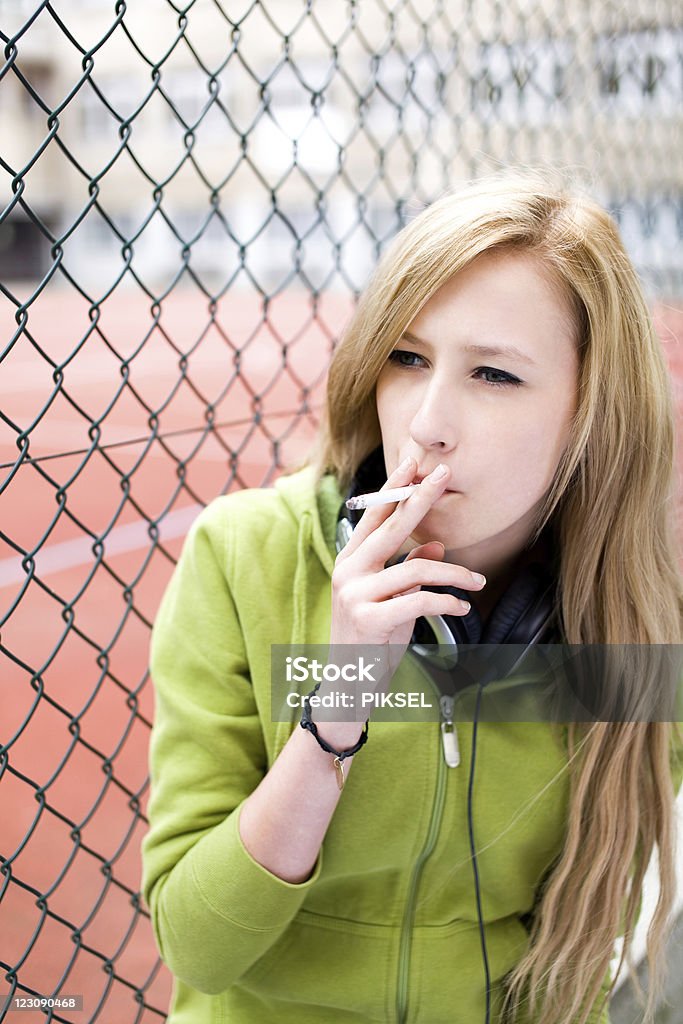 Ragazza adolescente fumare - Foto stock royalty-free di Cortile scolastico