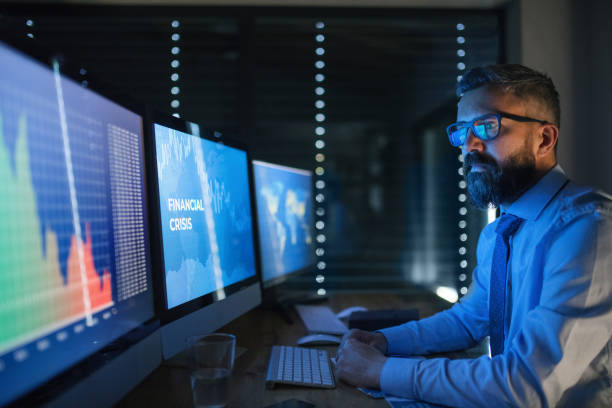 istock Businessman with computer sitting at desk, working late. Financial crisis concept. 1230913534